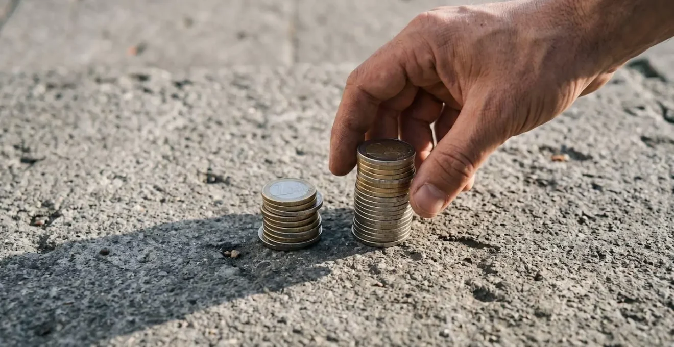 Deux piles inégales de pièces d'euros sur béton symbolisant l'arbitrage entre réparation directe et déclaration sinistre